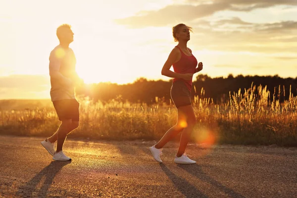 Junges Paar joggt nach Sonnenuntergang in der U-Bahn — Stockfoto