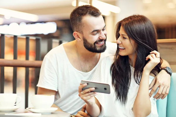 Casal romântico namoro no café e usando smartphone — Fotografia de Stock