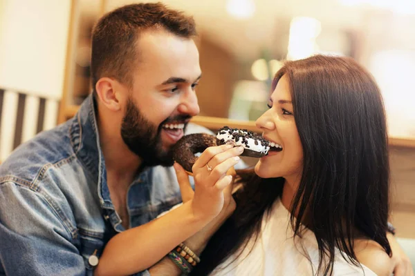 Casal romântico namoro no café e comer donut — Fotografia de Stock