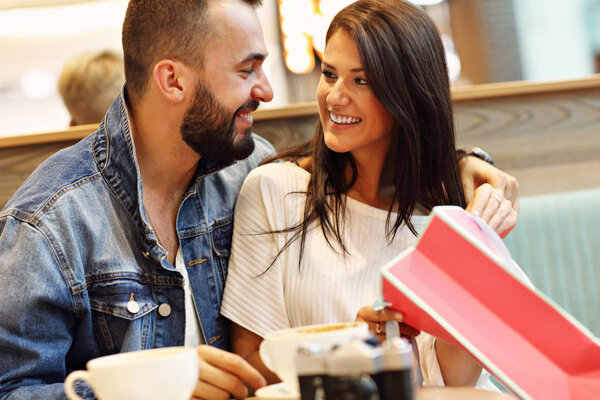 Happy couple with shopping bags in cafe