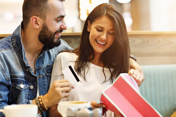 Pareja feliz con bolsas de compras en la cafetería —  Fotos de Stock