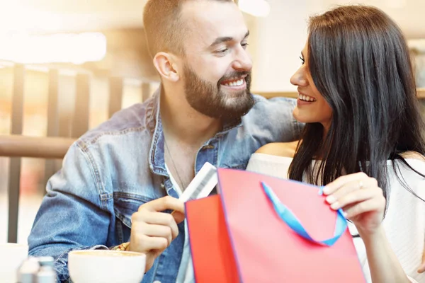 Casal feliz com sacos de compras no café — Fotografia de Stock