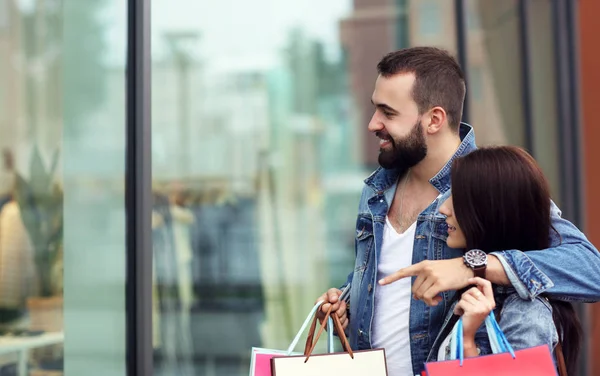 Portré a boldog pár bevásárló táskák vásárlás után a városban — Stock Fotó