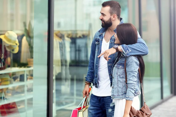 Retrato de casal feliz com sacos de compras depois de fazer compras na cidade — Fotografia de Stock