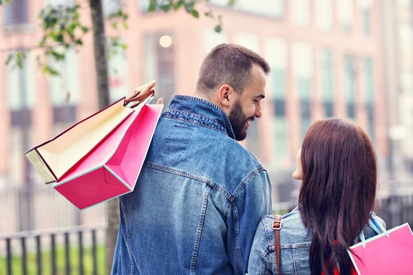 Retrato de pareja feliz con bolsas de compras después de comprar en la ciudad —  Fotos de Stock