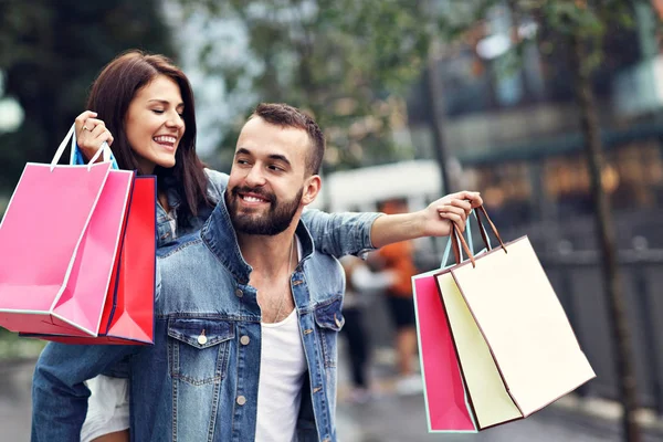 Retrato de casal feliz com sacos de compras depois de fazer compras na cidade — Fotografia de Stock