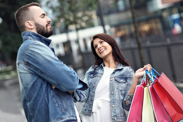 Retrato de pareja feliz con bolsas de compras después de comprar en la ciudad —  Fotos de Stock