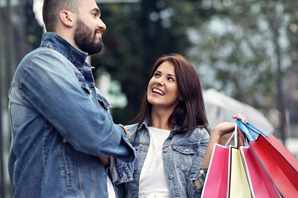 Retrato de pareja feliz con bolsas de compras después de comprar en la ciudad —  Fotos de Stock