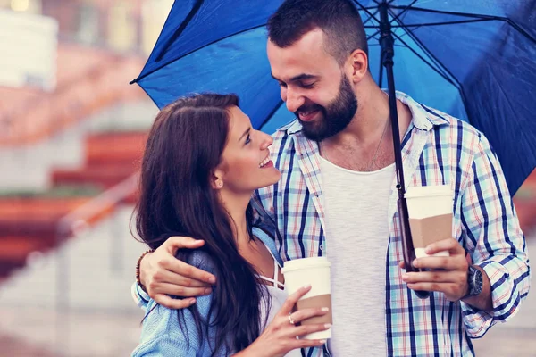 Happy couple under umbrella in the city — Stock Photo, Image
