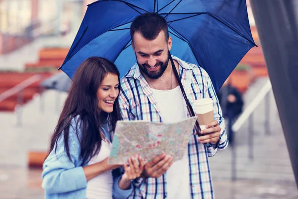 Heureux couple sous parapluie dans la ville — Photo