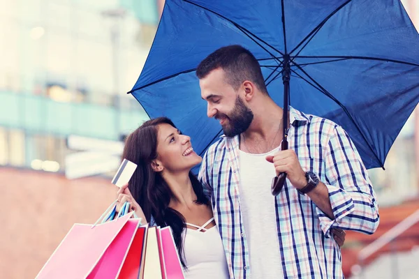 Portrait of happy couple with shopping bags after shopping in city — Stock Photo, Image