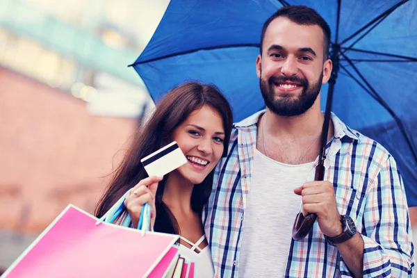 Портрет счастливой пары с сумками после шоппинга в городе — стоковое фото