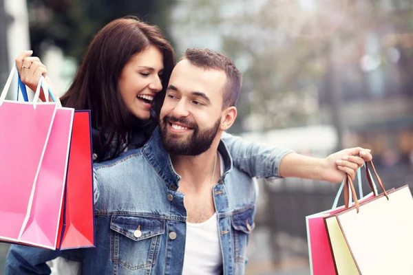 Portrait of happy couple with shopping bags after shopping in city — Stock Photo, Image