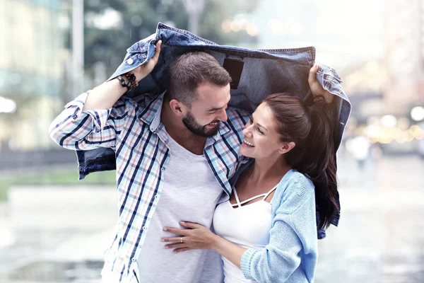 Glückliches Paar läuft im Regen in der Stadt — Stockfoto