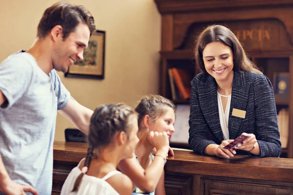 Feliz família check-in hotel na recepção — Fotografia de Stock