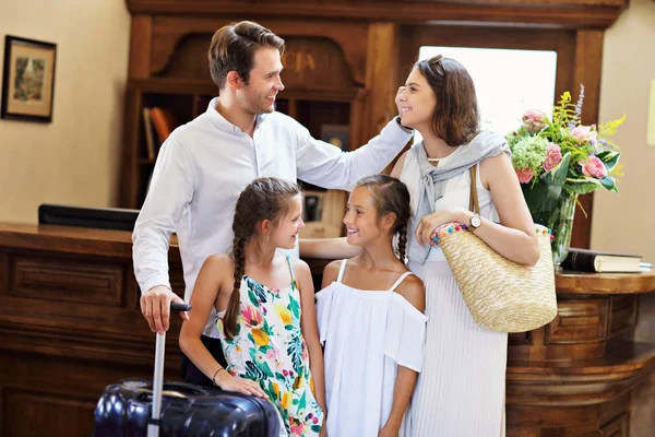 Feliz família check-in hotel na recepção — Fotografia de Stock
