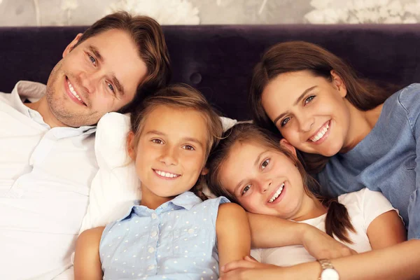 Feliz família relaxante no quarto de hotel — Fotografia de Stock