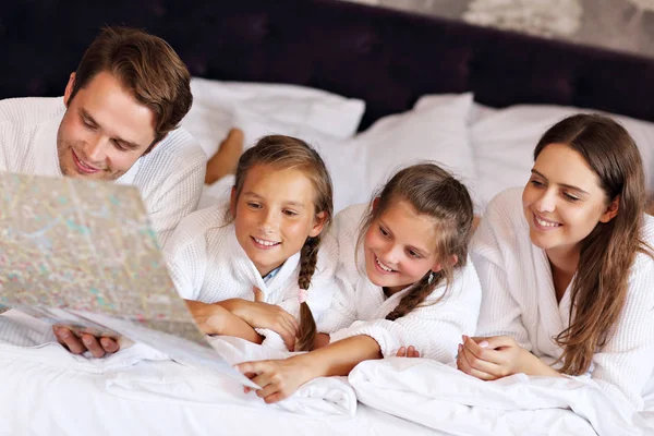 愉快的家庭放松在旅馆房间里 — 图库照片