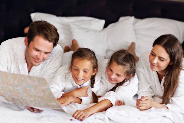 Feliz família relaxante no quarto de hotel — Fotografia de Stock