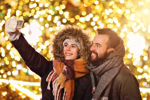 Casal adulto tomando selfie na cidade durante o Natal — Fotografia de Stock