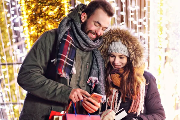 Pareja adulta de compras en la ciudad durante la Navidad —  Fotos de Stock