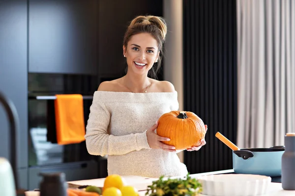 Erwachsene Frau in der Küche bereitet Kürbisgerichte für Halloween zu — Stockfoto