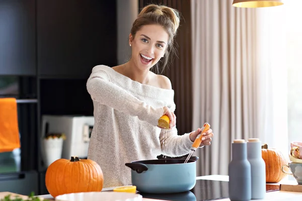 Erwachsene Frau in der Küche bereitet Kürbisgerichte für Halloween zu — Stockfoto