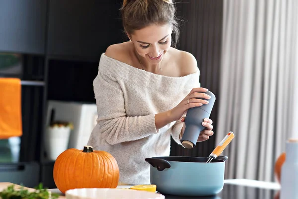 Mulher adulta na cozinha preparando pratos de abóbora para o Halloween — Fotografia de Stock