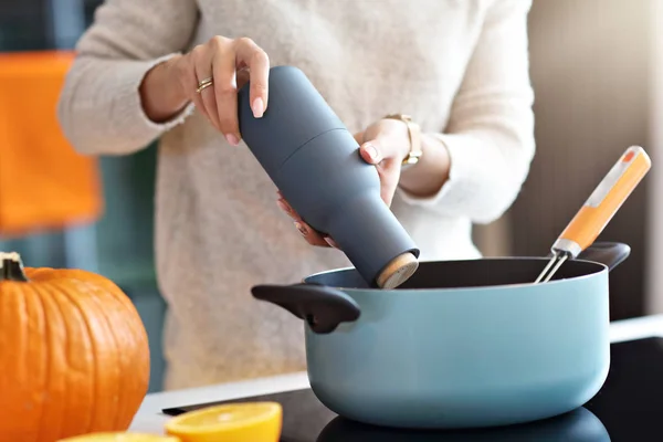 Donna adulta in cucina che prepara piatti di zucca per Halloween — Foto Stock