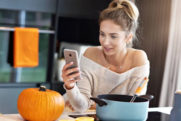 Adult woman in the kitchen preparing pumpkin dishes for Halloween — Stock Photo, Image