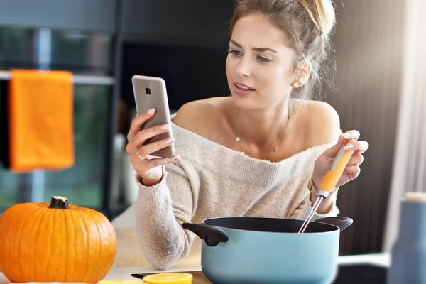 Mulher adulta na cozinha preparando pratos de abóbora para o Halloween — Fotografia de Stock