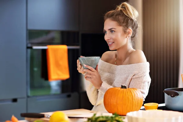 Mulher adulta na cozinha preparando pratos de abóbora para o Halloween — Fotografia de Stock