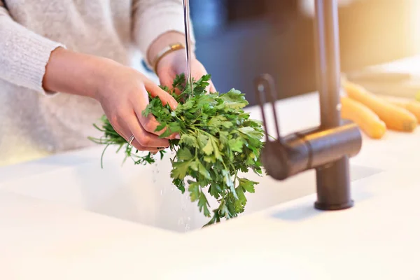 Felnőtt nő mosás petrezselymet a konyhában — Stock Fotó