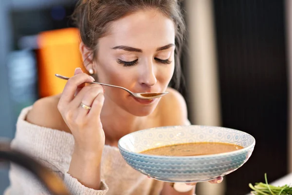 Dospělé ženy jíst Dýňová polévka v kuchyni — Stock fotografie
