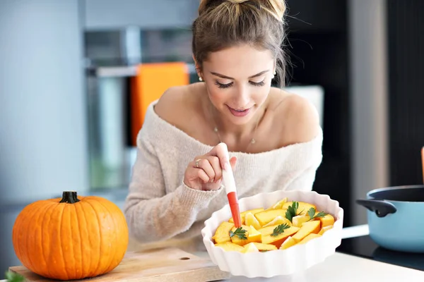 Erwachsene Frau in der Küche bereitet Kürbisgerichte für Halloween zu — Stockfoto