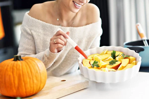 Erwachsene Frau in der Küche bereitet Kürbisgerichte für Halloween zu — Stockfoto
