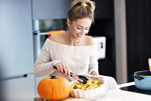 Erwachsene Frau in der Küche bereitet Kürbisgerichte für Halloween zu — Stockfoto