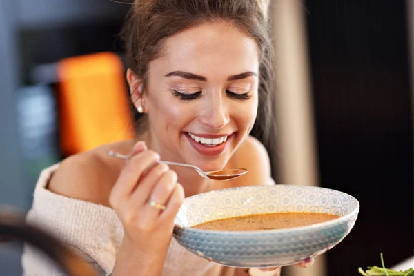 Erwachsene Frau isst Kürbissuppe in der Küche — Stockfoto