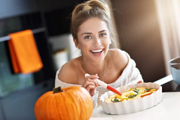 Erwachsene Frau in der Küche bereitet Kürbisgerichte für Halloween zu — Stockfoto