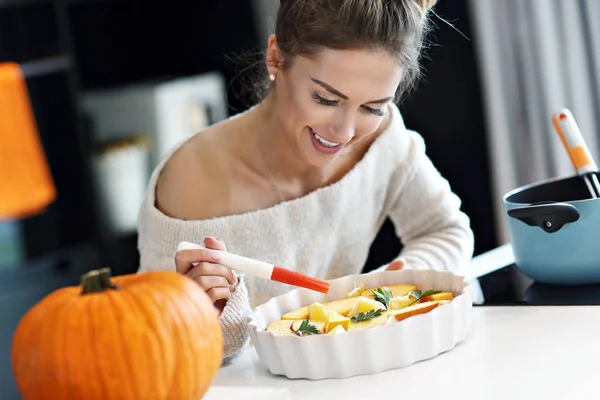 Volwassen vrouw in de keuken bereiden van gerechten van de pompoen voor Halloween — Stockfoto