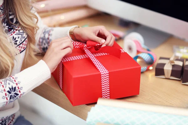 Mujer adulta en casa envolviendo regalos de Navidad —  Fotos de Stock