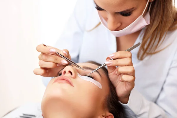 Adult woman having eyelash extension in professional beauty salon — Stock Photo, Image