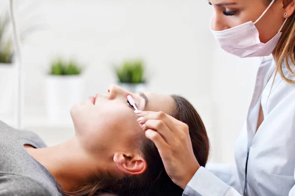 Adult woman having eyelash extension in professional beauty salon — Stock Photo, Image