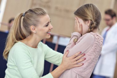 Küçük kız annesiyle birlikte iken bir doktor Danışma üzerinde ağlıyor