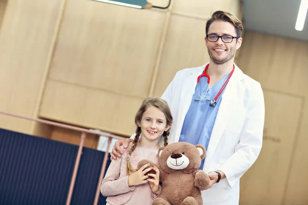 Médico dando la bienvenida a niña en la clínica — Foto de Stock