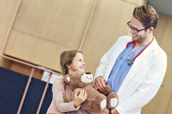 Doktor vítá holčička v klinice — Stock fotografie