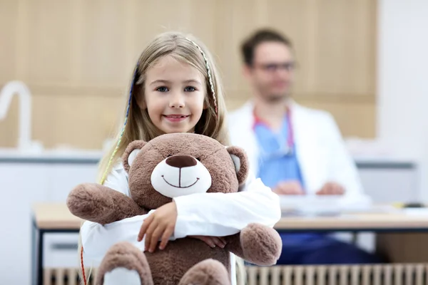 Bambina in clinica con pediatra sullo sfondo — Foto Stock