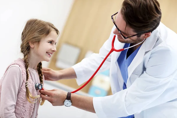 Klein meisje in kliniek met een checkup met kinderarts — Stockfoto