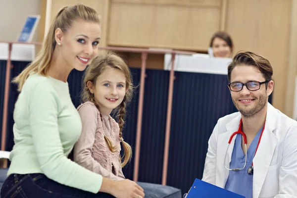 Médico dando la bienvenida a madre e hija en clínica — Foto de Stock