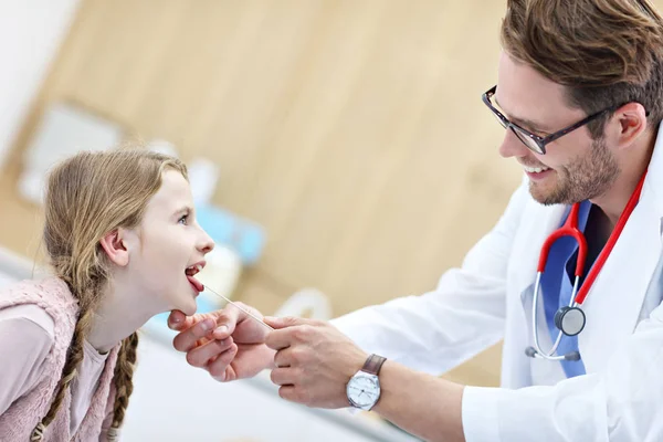 Klein meisje in kliniek met een checkup met laryngologist — Stockfoto